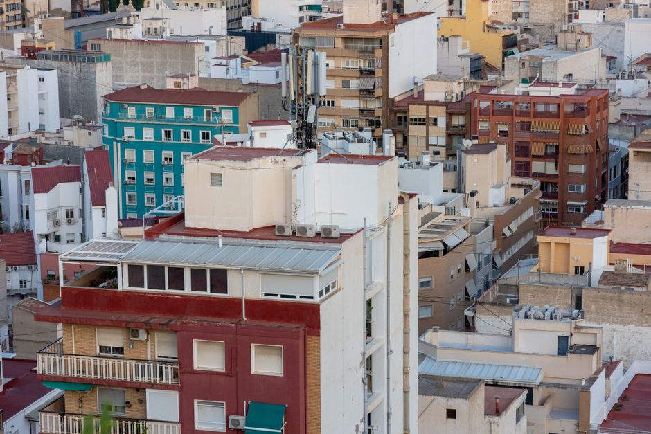 Aerial shot of urban residential rooftops with vibrant building colors in cityscape.